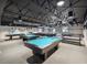 Community game room featuring billiard tables, gray carpet, and a high dark painted ceiling with industrial lighting at 11536 Golden Rain Dr, New Port Richey, FL 34654