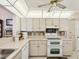 Functional kitchen with white cabinets, double oven, dishwasher and a pass-through to the dining area at 11536 Golden Rain Dr, New Port Richey, FL 34654