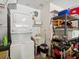 Efficient laundry room with stacked washer and dryer, utility sink, and ample storage shelving at 11536 Golden Rain Dr, New Port Richey, FL 34654