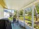 Covered outdoor patio with screen enclosure, a chair, a grill, and a view of the spacious backyard at 11536 Golden Rain Dr, New Port Richey, FL 34654