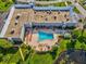 Overhead view of community pool area with lounge chairs and lush landscaping near a lake at 11536 Golden Rain Dr, New Port Richey, FL 34654