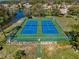 Aerial view of community tennis courts with lake and residential homes in the background at 11648 Boynton Ln # 39Gb, New Port Richey, FL 34654