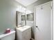 Cozy bathroom featuring a vanity with storage, a decorative mirror, and a toilet at 11648 Boynton Ln # 39Gb, New Port Richey, FL 34654