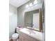 Cozy bathroom featuring a vanity with storage, a decorative mirror, and a toilet at 11648 Boynton Ln # 39Gb, New Port Richey, FL 34654