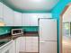 Bright kitchen with white cabinets, black countertops, stainless steel appliances, and access to the living room at 11648 Boynton Ln # 39Gb, New Port Richey, FL 34654