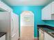 Bright kitchen featuring white cabinets, black countertops, and stainless steel appliances plus access to other room at 11648 Boynton Ln # 39Gb, New Port Richey, FL 34654