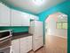 Bright kitchen featuring white cabinets, black countertops, and modern appliances plus view to living space at 11648 Boynton Ln # 39Gb, New Port Richey, FL 34654