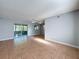 Open-concept living space with tiled floors, ceiling fan, and sliding glass doors to the lanai at 11648 Boynton Ln # 39Gb, New Port Richey, FL 34654