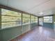 Bright sunroom with tile flooring and large windows offering serene views of the lush, green surroundings at 11648 Boynton Ln # 39Gb, New Port Richey, FL 34654