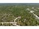 A wooded landscape shows a house, road, and trees in an aerial view at 11730 Hawks Nest Trl, Brooksville, FL 34614