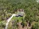 Birds-eye view of a well-maintained home surrounded by mature trees and a lush, manicured lawn at 11730 Hawks Nest Trl, Brooksville, FL 34614