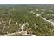 A lush, green aerial view shows the lot and community, with trees and a house in view at 11730 Hawks Nest Trl, Brooksville, FL 34614
