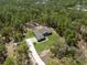 Aerial shot of a well-manicured home with a long driveway and lush greenery, creating a private oasis at 11730 Hawks Nest Trl, Brooksville, FL 34614