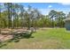 Backyard with green grass, bordered by woods, showing a tank and septic system feature at 11730 Hawks Nest Trl, Brooksville, FL 34614