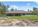 Spacious backyard showcases the home's exterior, lush greenery, and outdoor features at 11730 Hawks Nest Trl, Brooksville, FL 34614