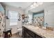 Well-lit bathroom featuring a granite countertop, stylish fixtures, and a window offering natural light at 11730 Hawks Nest Trl, Brooksville, FL 34614
