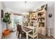 Charming dining room featuring a rustic table, elegant shelving, and a view to outside at 11730 Hawks Nest Trl, Brooksville, FL 34614