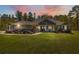 Charming single-story home with well-manicured lawn and landscaping at dusk at 11730 Hawks Nest Trl, Brooksville, FL 34614