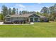Well-maintained home with manicured lawn, mature trees, and charming details like rocking chairs at 11730 Hawks Nest Trl, Brooksville, FL 34614