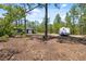 Property view featuring a travel trailer and shed in a wooded landscape under a sunny sky at 11730 Hawks Nest Trl, Brooksville, FL 34614