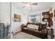 Inviting living room with a brown leather couch, side tables, decorative shelves, and ample natural light at 11730 Hawks Nest Trl, Brooksville, FL 34614