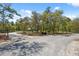 Gated home entrance with gravel road, trees, and mailbox creates a welcoming approach to this stunning property at 11730 Hawks Nest Trl, Brooksville, FL 34614
