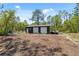 Exterior shot of a shed with two garage doors on a wooded lot under a clear sky at 11730 Hawks Nest Trl, Brooksville, FL 34614
