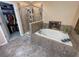 Bathroom featuring a soaking tub, tiled shower, and walk-in closet at 11796 Crestridge Loop, New Port Richey, FL 34655