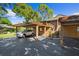 Exterior view of a home with carport and staircase to front door at 1208 Cypress Pond Rd, Palm Harbor, FL 34683