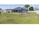 A partially fenced backyard featuring a screened-in lanai and pool, surrounded by a lush lawn at 1216 Yawl Way, Venice, FL 34285