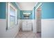Bright and airy bathroom with light blue walls, white wainscoting, and a white vanity cabinet at 1216 Yawl Way, Venice, FL 34285