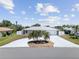 Well-maintained home with a lush lawn, palm trees, and an expansive driveway under a sunny sky at 1216 Yawl Way, Venice, FL 34285