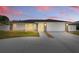Charming single-story home with a well-manicured lawn and a two-car garage at dusk at 1216 Yawl Way, Venice, FL 34285