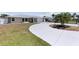 Charming home with a well-manicured lawn, stone accents, and a long driveway leading to an attached garage at 1216 Yawl Way, Venice, FL 34285
