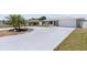 Home with a well-manicured lawn, stone accents, and a long driveway leading to an attached garage at 1216 Yawl Way, Venice, FL 34285