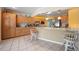 Spacious kitchen featuring granite countertops, wooden cabinets, and a breakfast bar at 1216 Yawl Way, Venice, FL 34285
