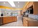 Well-lit kitchen with granite countertops, wood cabinets, and modern stainless steel appliances at 1216 Yawl Way, Venice, FL 34285