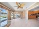 Bright living room with a ceiling fan, tile floors, and sliding glass doors to the pool area at 1216 Yawl Way, Venice, FL 34285