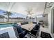 Outdoor dining area features a large table and chairs under a screened enclosure near a pool and grill at 1216 Yawl Way, Venice, FL 34285