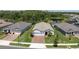 Aerial view of a house with a well-maintained lawn, landscaping and nearby water feature at 12617 Wetmore Ct, Odessa, FL 33556