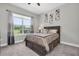 A well-lit bedroom with a queen-size bed, soft carpet, and a serene view from the window at 12617 Wetmore Ct, Odessa, FL 33556