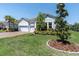 Charming home with manicured lawn and a three-car garage, featuring a beautiful entryway and landscaping at 12617 Wetmore Ct, Odessa, FL 33556