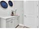 Laundry room with gray cabinets and countertops, decorated with modern decor at 12617 Wetmore Ct, Odessa, FL 33556