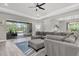 Bright living room with tray ceilings, a gray sectional sofa, and sliding doors leading to the patio at 12617 Wetmore Ct, Odessa, FL 33556