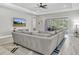 Spacious living room with a plush sectional couch, modern ceiling fan, and sliding glass doors at 12617 Wetmore Ct, Odessa, FL 33556