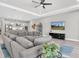 Open-concept living space with a gray sectional sofa, TV, and view into modern kitchen at 12617 Wetmore Ct, Odessa, FL 33556