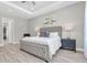 The main bedroom offers a tufted headboard, neutral tones, and wood-look tile flooring for a calming atmosphere at 12617 Wetmore Ct, Odessa, FL 33556