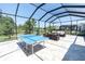 Spacious screened-in patio with a ping pong table and outdoor seating area at 12617 Wetmore Ct, Odessa, FL 33556