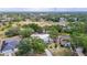 Expansive aerial view of a home featuring a metal roof, screened-in pool, and lush landscaping nestled amongst mature trees at 1276 Meredith Dr, Spring Hill, FL 34608