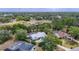 An aerial of the home showcases the metal roof, lush landscaping, and two private screened-in pools at 1276 Meredith Dr, Spring Hill, FL 34608